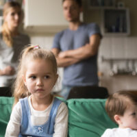 Kid girl upset, offended or bored ignoring parents and brother