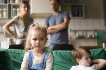 Kid girl upset, offended or bored ignoring parents and brother